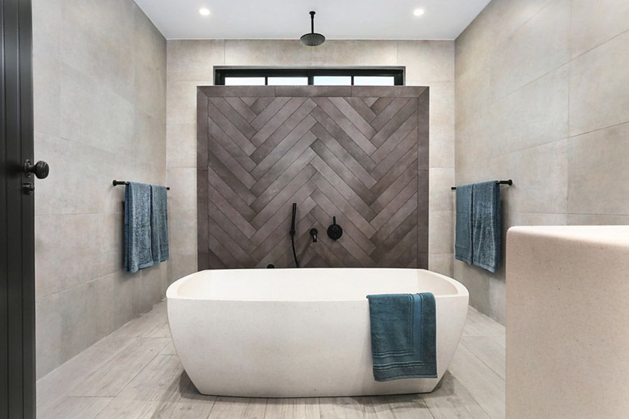 Bathroom with freestanding bath and herringbone timber feature wall